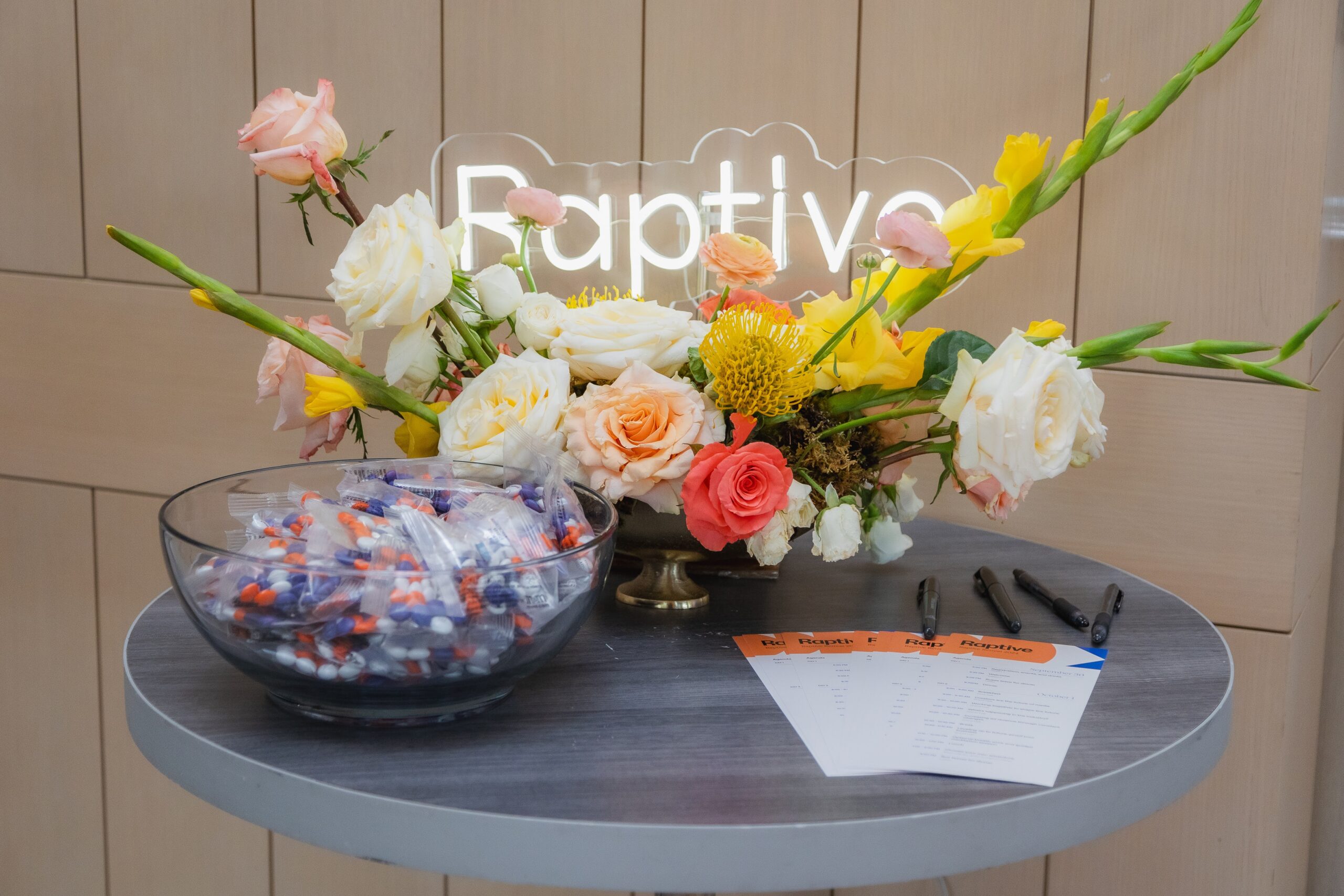 Custom florals for a corporate business event with a branded neon sign.