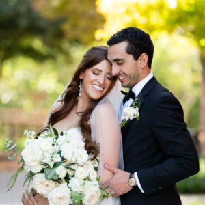 Portraits of the bride and groom with her lush white floral bouquet by Render Events.